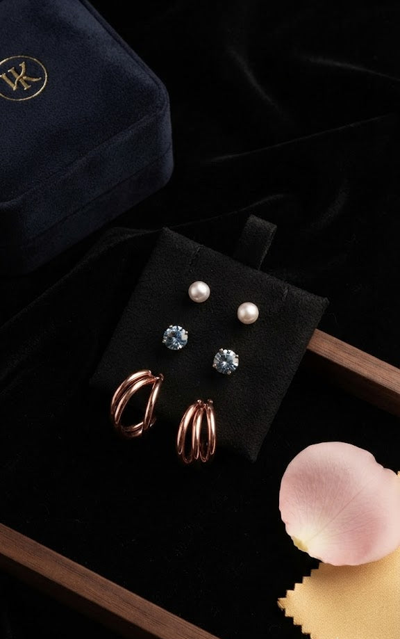 Close-up of rose gold triple hoop earrings, pearl studs and blue CZ studs in open navy velvet jewellery box – AureliaBlends gift set