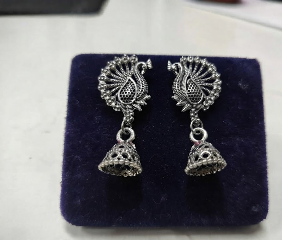 Three pairs of oxidized silver peacock jhumka earrings on blue fashion display card – Indian ethnic dangle earrings by AureliaBlends