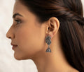 Close-up of oxidized silver peacock jhumka earrings on navy blue velvet – handcrafted antique silver dangle drop earrings AureliaBlends