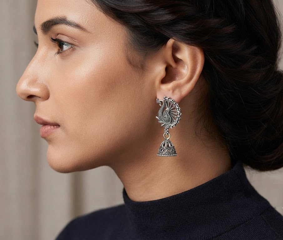 Woman wearing oxidized silver peacock jhumka earrings with half-up hairstyle – Indian statement dangle earrings by AureliaBlends