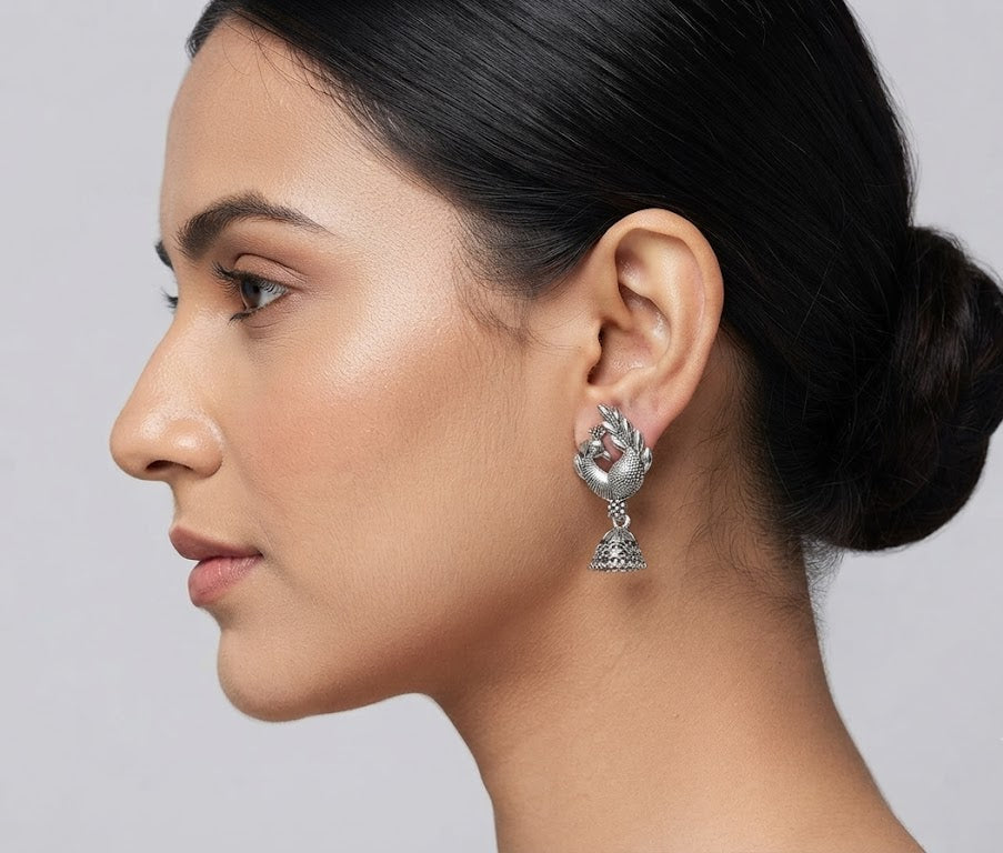 Model wearing oxidized silver peacock jhumka earrings with sleek bun hairstyle – antique silver ethnic drop earrings by AureliaBlends