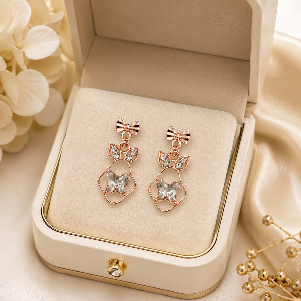 Rose gold bow and butterfly crystal drop earrings flat lay on cream satin with gypsophila and For You With Love gift card – AureliaBlends