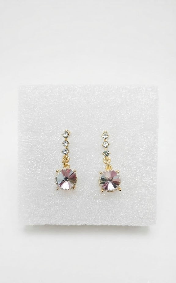Gold CZ chain and blush rivoli crystal drop earrings displayed in open navy blue velvet jewellery box on marble vanity with perfume bottle – AureliaBlends