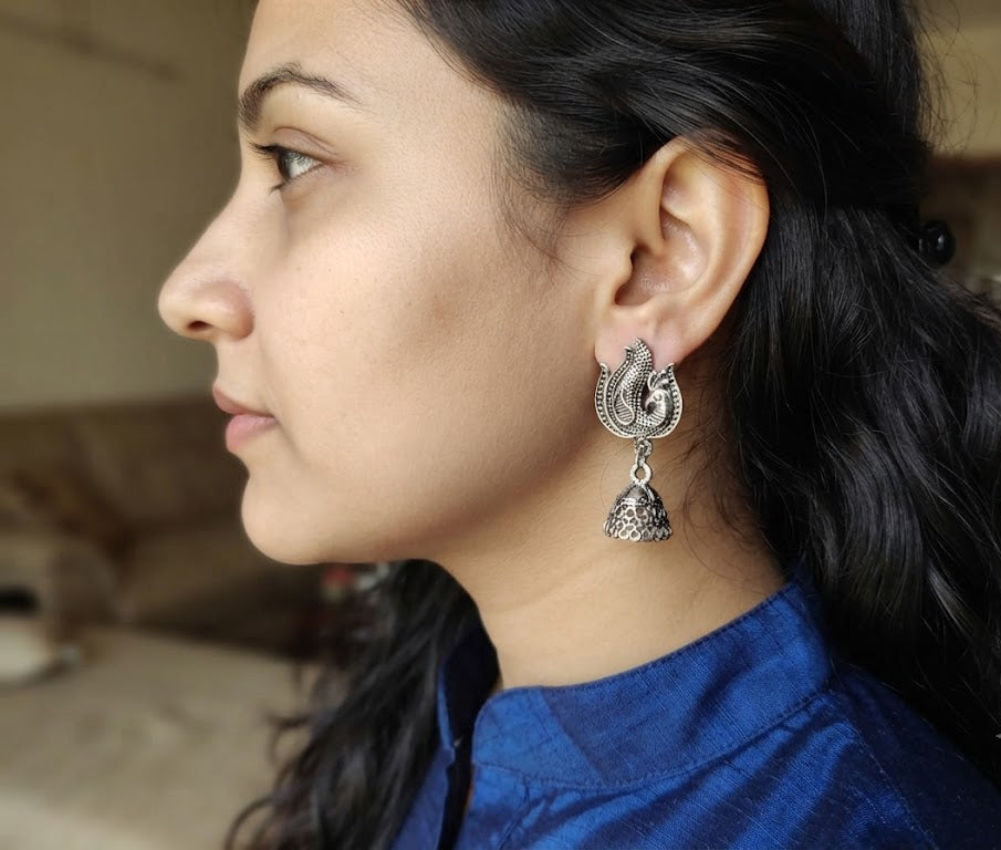 Oxidized silver phoenix bird jhumka earrings on blue fashion display card on navy velvet with vintage accessories – AureliaBlends lifestyle flat lay
