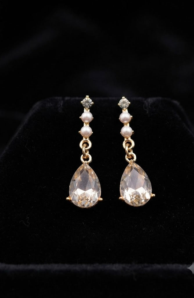 Close-up of gold CZ stud, faux pearl bead chain and large faceted clear teardrop crystal pendant on black velvet – AureliaBlends bridal drop earrings