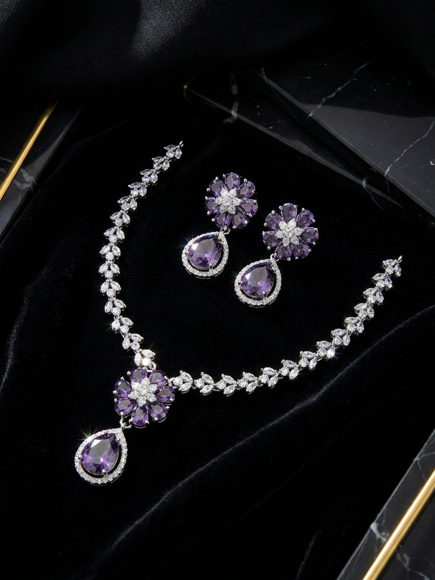 Amethyst purple CZ flower teardrop necklace and earrings set flat lay on purple satin with lavender sprigs and chestnuts – AureliaBlends luxury jewelry