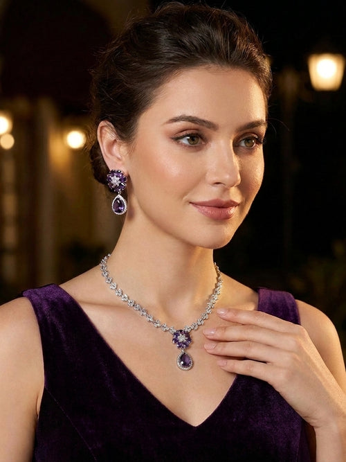 Amethyst purple CZ flower teardrop necklace and earrings set flat lay on cream satin – purple bridal jewelry set AureliaBlends
