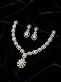 Model wearing silver cubic zirconia bridal necklace and earring set with a navy off-shoulder gown in an elegant interior – AureliaBlends