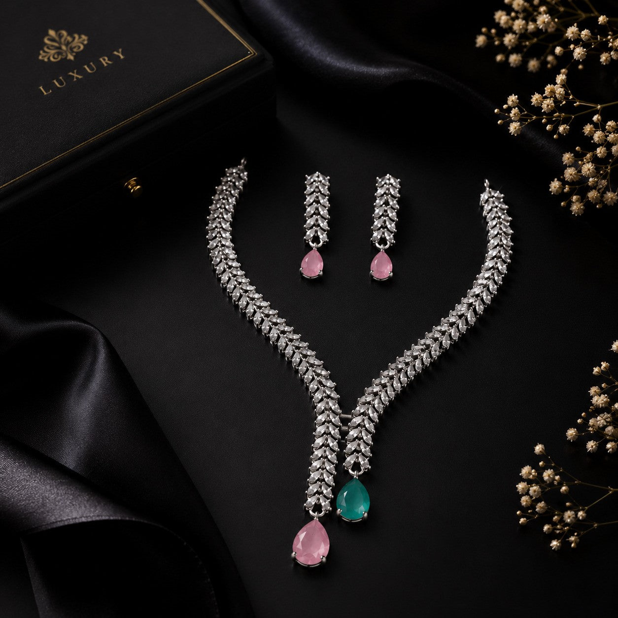 Close-up of pink and green CZ wheat chain V-necklace and matching drop earrings on dark satin – AureliaBlends statement wedding jewelry
