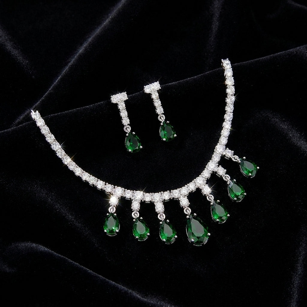 Emerald green CZ teardrop necklace and earring set displayed in an open dark green leather jewelry box on gold satin – AureliaBlends luxury bridal jewelry