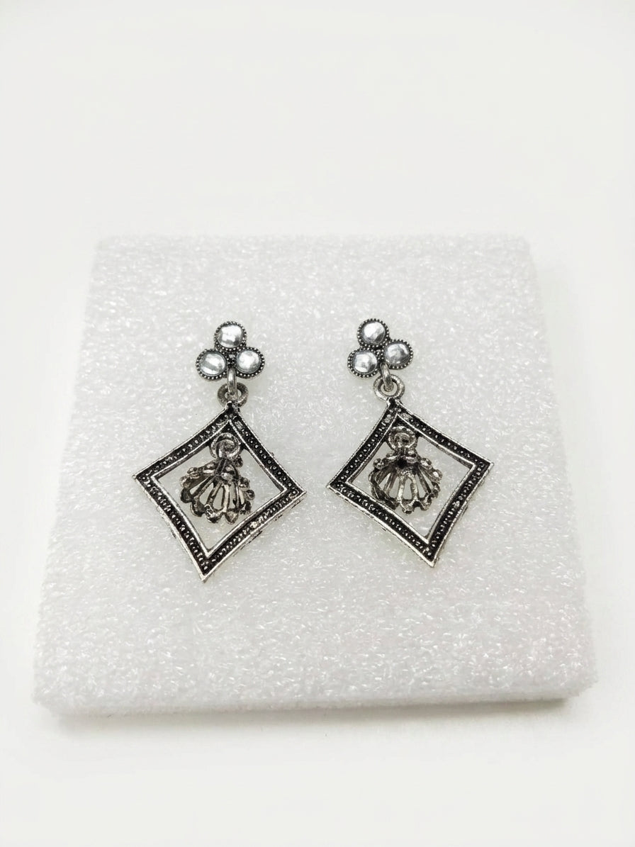 Oxidised silver pearl trefoil stud and diamond frame jhumka drop earrings flat lay on cream linen with white jasmine flowers, eucalyptus and silver tray – AureliaBlends ethnic earrings