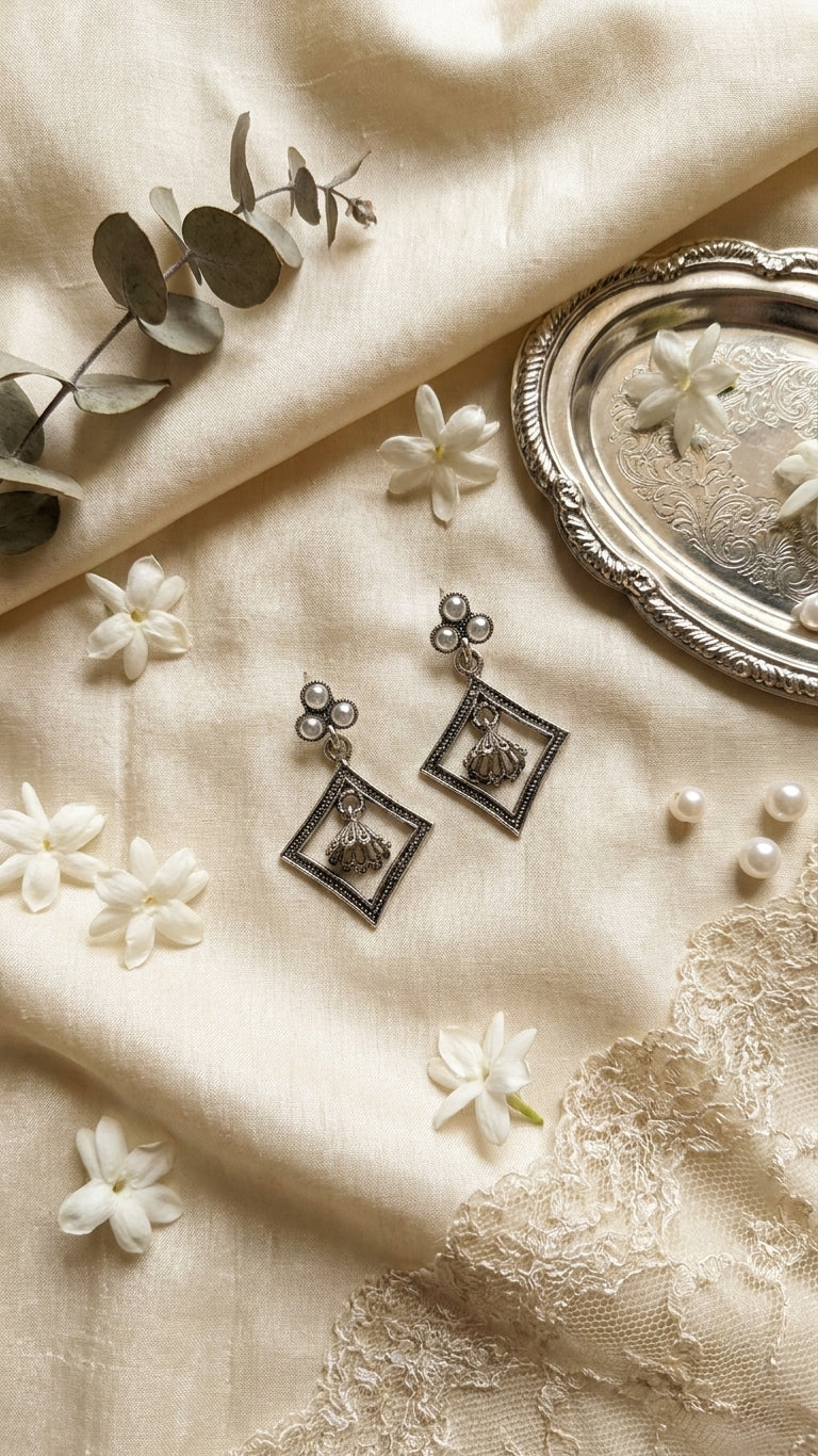 Oxidised silver pearl trefoil stud and open diamond frame jhumka drop earrings on black velvet background with scattered pearls – AureliaBlends antique silver earrings