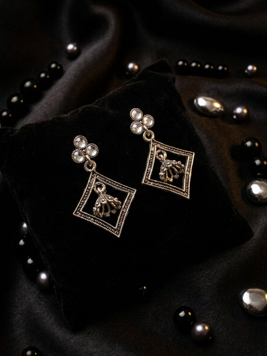 AureliaBlends oxidised silver pearl trefoil and diamond frame jhumka drop earrings lifestyle flat lay on cream linen with jasmine flowers and antique silver tray
