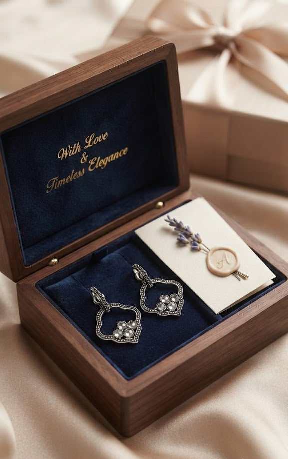 Oxidised silver quatrefoil pearl drop earrings flat lay on cream linen with walnut wood jewellery box, silver spoon, lavender sprigs and stone – AureliaBlends lifestyle