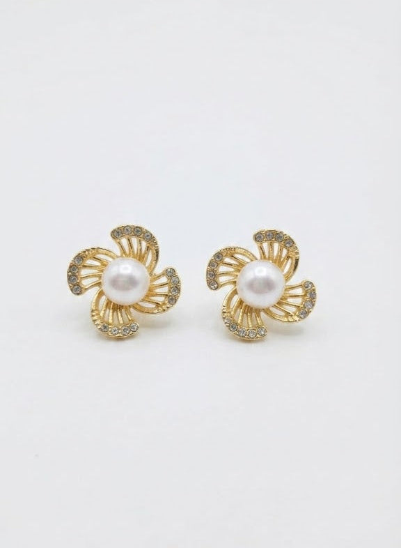 Model wearing gold pavé CZ swirl floral pearl stud earrings with a sleek updo in a warm luxury interior – AureliaBlends Elegance Collection side profile