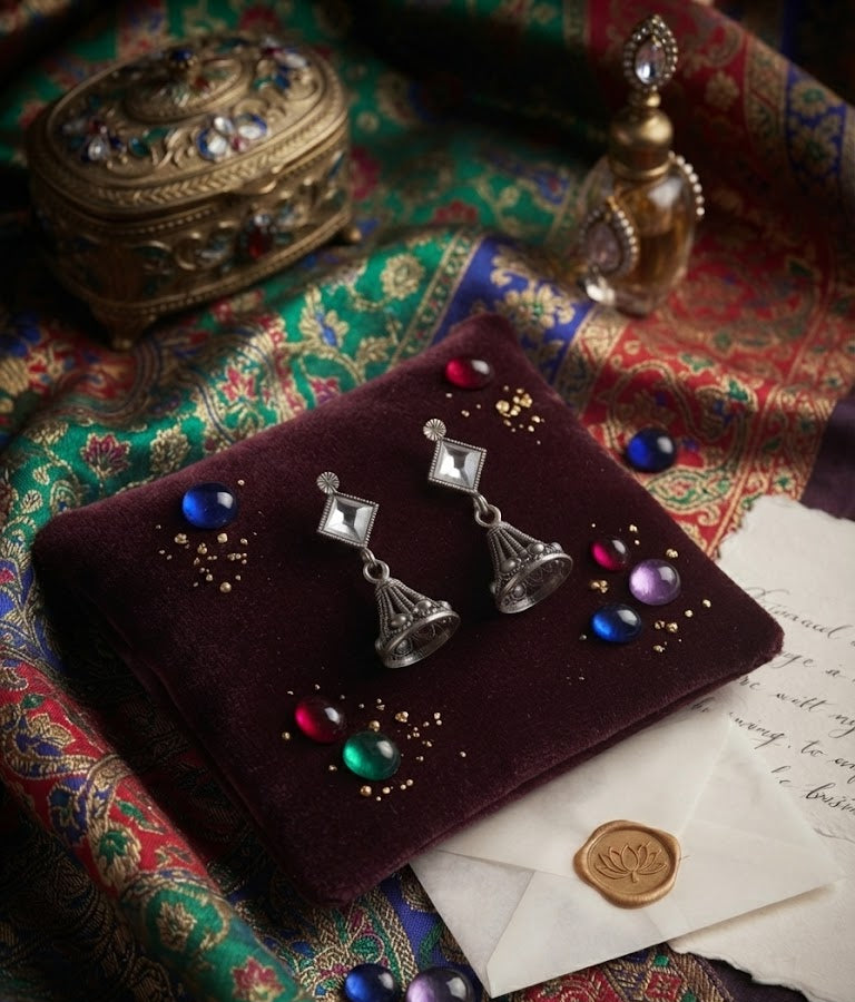 AureliaBlends oxidised silver diamond CZ stud and open filigree jhumka bell drop earrings lifestyle editorial flat lay on dark walnut wood with vintage accessories, lotus wax seal and plum satin ribbon