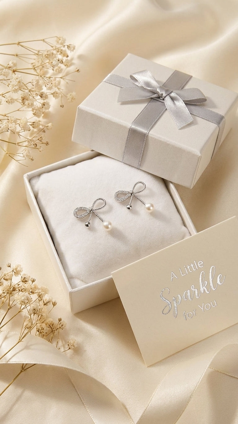 Silver CZ twisted rope bow pearl drop earrings on pink satin fabric – AureliaBlends romantic bridal earrings product shot