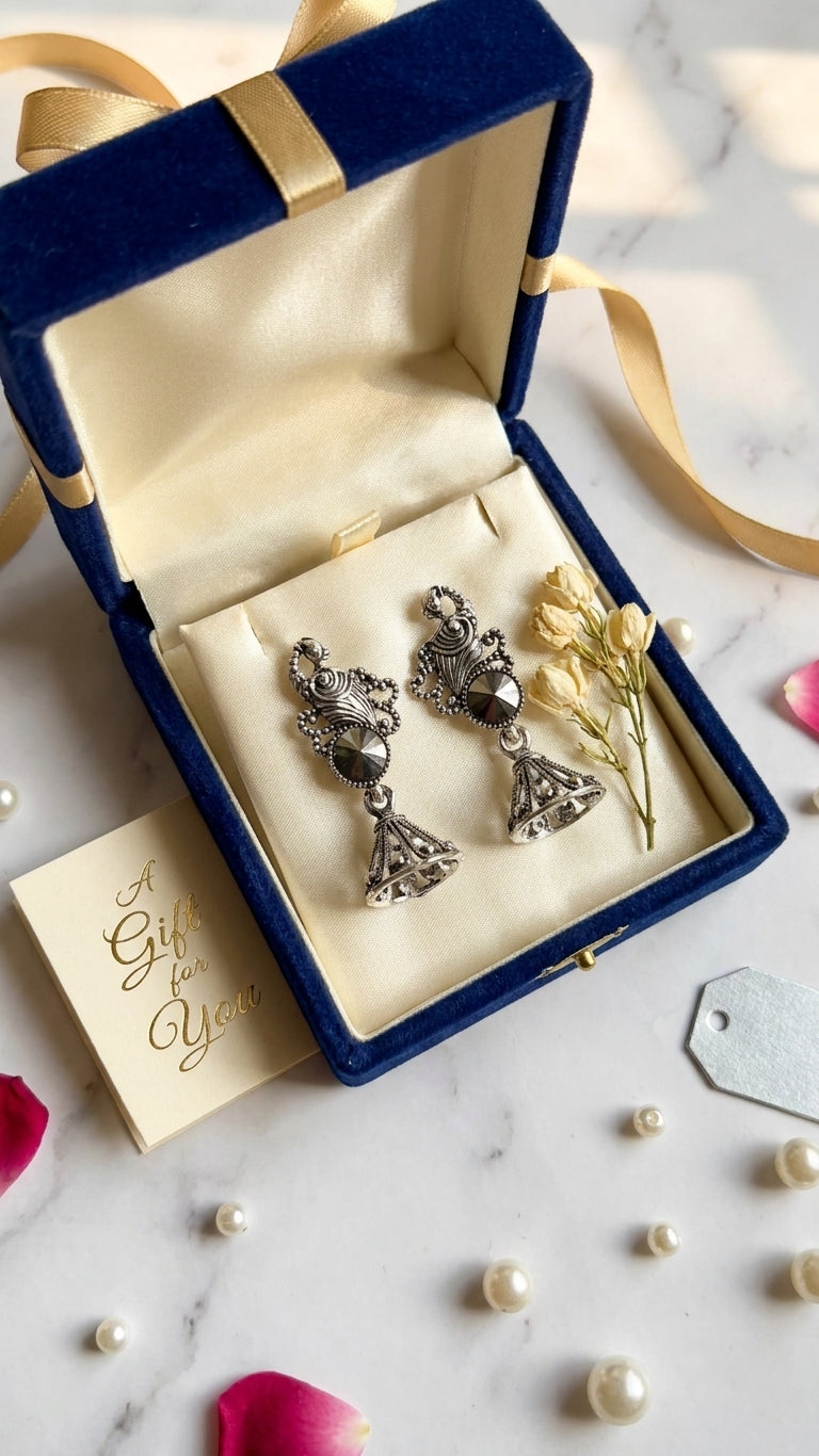 Oxidised silver peacock scroll and hematite rivoli jhumka bell drop earrings on forest green velvet with pearl necklace, gold zari embroidered fabric and blue silk drape – AureliaBlends ethnic festive earrings