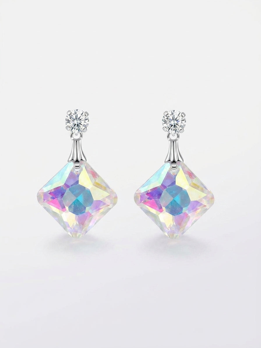 Model wearing silver CZ round solitaire stud and large square aurora borealis iridescent crystal drop earrings in diamond orientation showing rainbow pink purple blue shimmer – AureliaBlends crystal dangle earrings