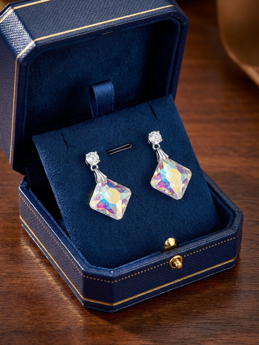 Silver CZ stud and aurora borealis iridescent square crystal drop earrings flat lay on dark navy velvet with dried burgundy roses, pink satin ribbon, lavender sprig and antique silver hand mirror – AureliaBlends