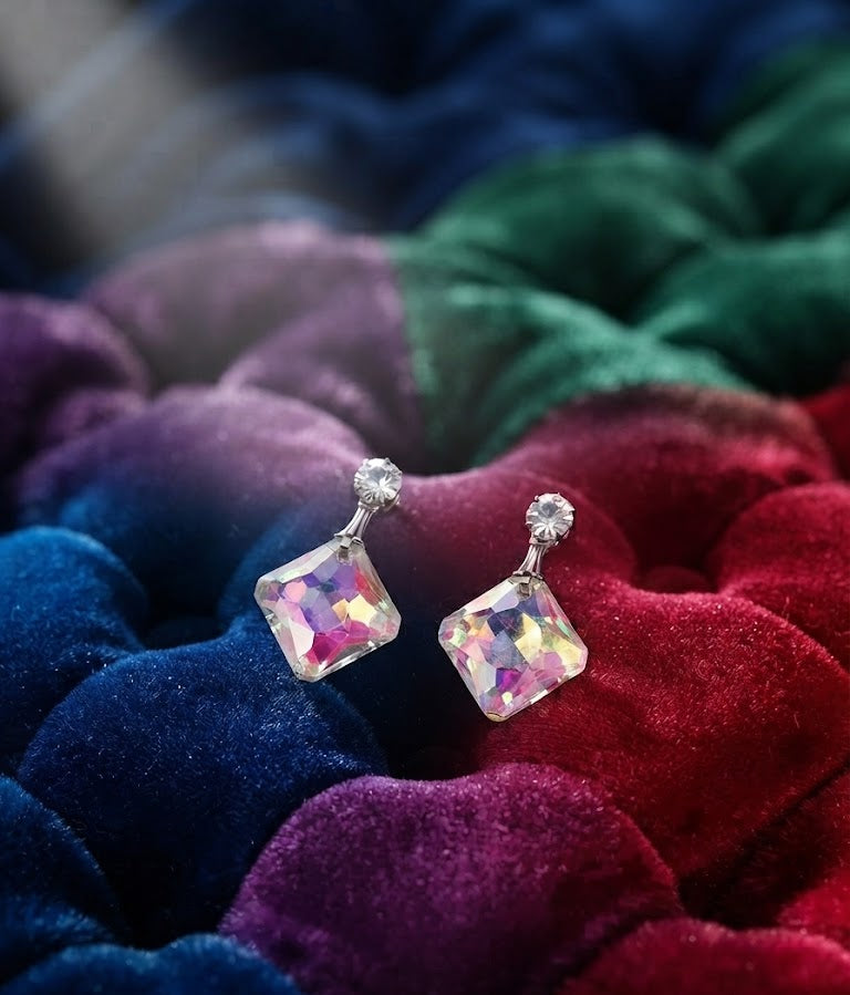 Close-up of silver CZ round solitaire stud and large square aurora borealis iridescent crystal pendant in diamond orientation showing full rainbow pink violet blue gold shimmer – AureliaBlends crystal drop earrings detail