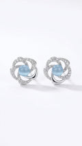 Model wearing silver pavé CZ swirl floral moonstone stud earrings with a sleek low bun – close-up side profile on warm neutral background – AureliaBlends something blue bridal earrings