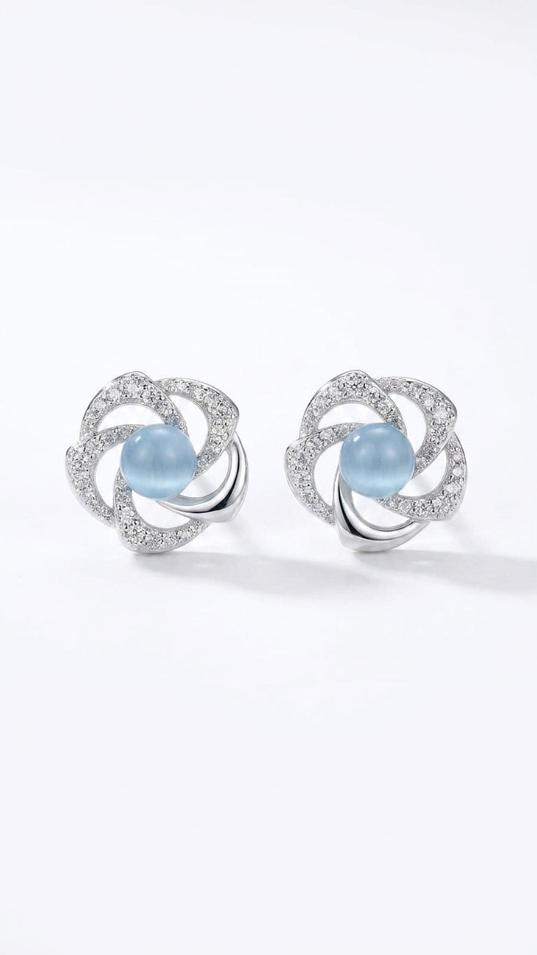 Model wearing silver pavé CZ swirl floral moonstone stud earrings with a sleek low bun – close-up side profile on warm neutral background – AureliaBlends something blue bridal earrings