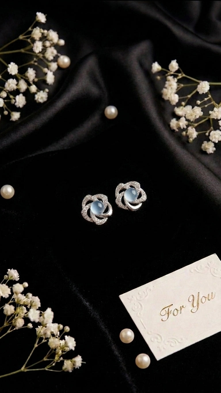 Silver pavé CZ swirl floral moonstone stud earrings in an open emerald green velvet gift box with ivory satin bow on black satin with baby’s breath, loose pearls and a ‘For You’ card – AureliaBlends