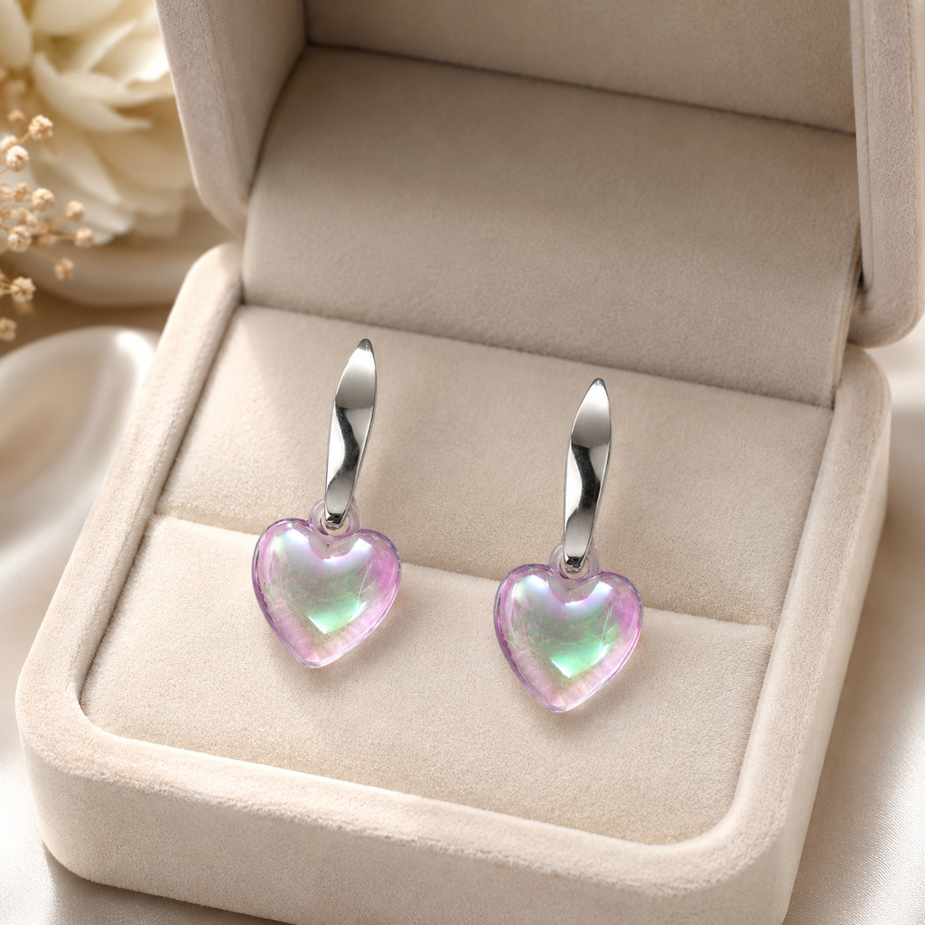 Silver twisted huggie hoop and puffy iridescent aurora heart crystal drop earrings flat lay on cream satin with dried white peony, gypsophila, gold scalloped dish and pearl necklace – AureliaBlends romantic dangle earrings