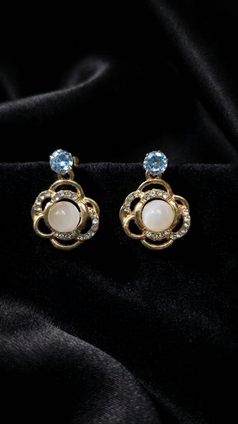 Gold open floral CZ pearl drop earrings with aquamarine blue CZ stud on black velvet background showing open floral pendant, CZ halo and pearl centre detail – AureliaBlends statement dangle earrings