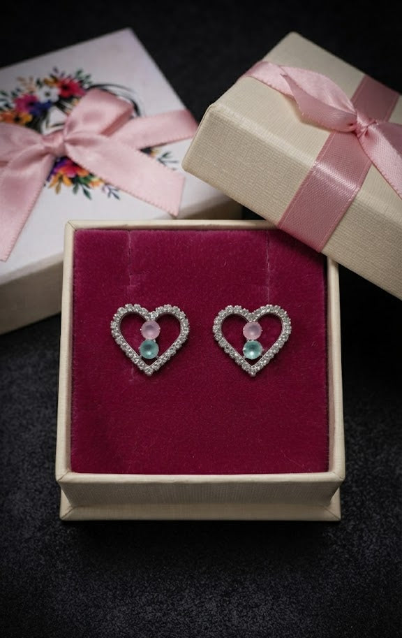 Silver pavé CZ open heart pink and aquamarine stone stud earrings on dark moody purple velvet background with a four-pointed star sparkle – AureliaBlends statement heart stud earrings dark editorial