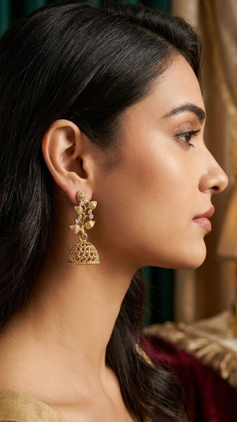 Gold-plated CZ botanical leaf vine and open filigree dome jhumka bell drop earrings on blush pink satin surrounded by blush peach roses ranunculus white jasmine gypsophila and lace ribbon – AureliaBlends bridal earrings
