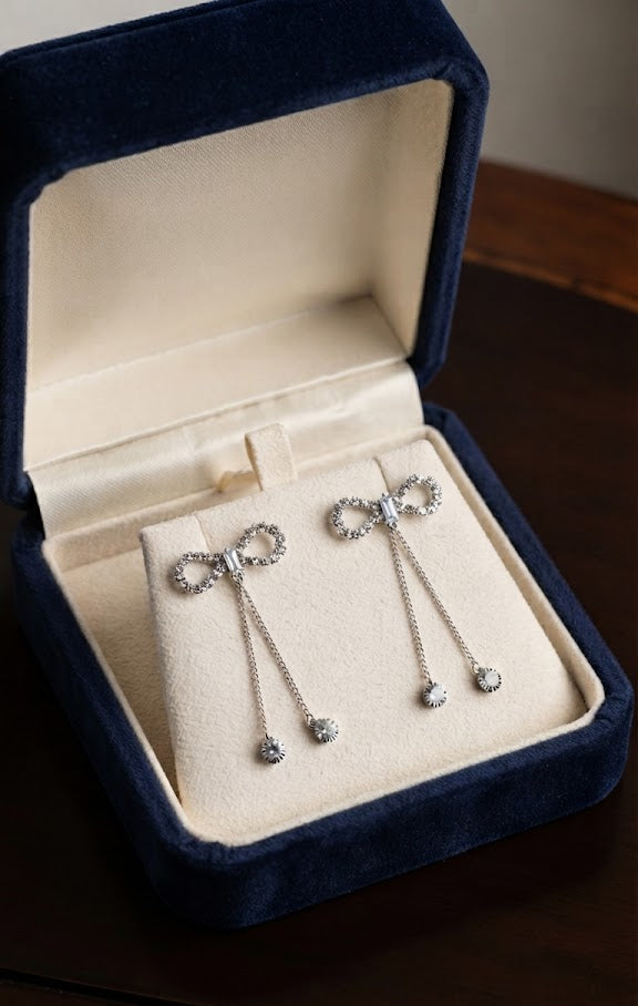 Silver CZ open bow tassel chain drop earrings product shot on white background showing full pavé CZ open bow top and three silver chain tassel drops with round CZ solitaire ends – AureliaBlends bridal earrings
