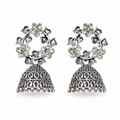 Oxidised silver CZ floral wreath and open oval lattice jhumka bell drop earrings flat lay on cream white satin with large white dahlia flower gypsophila and gold-rimmed ceramic dish – AureliaBlends ethnic jhumka earrings