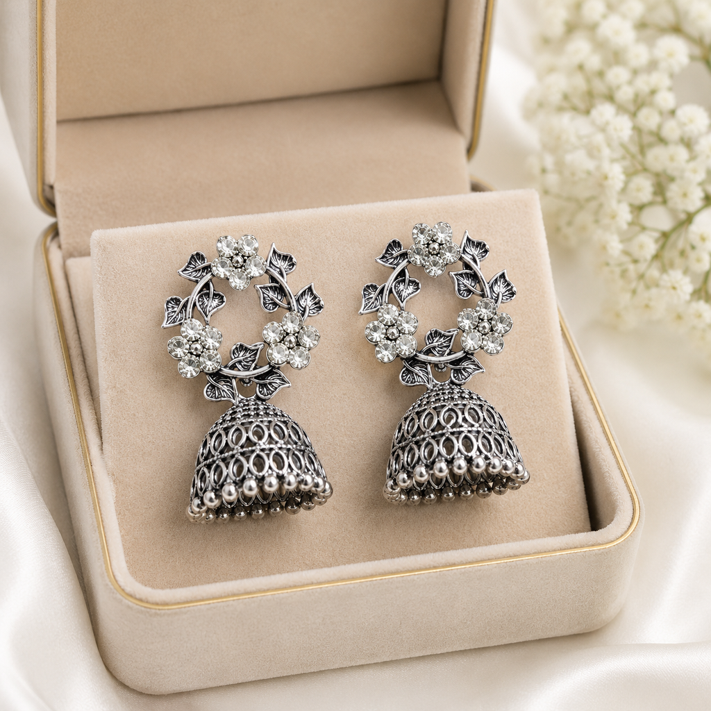 Oxidised silver CZ floral wreath and open oval lattice jhumka bell drop earrings flat lay on pink marble with blush pink roses scattered rose petals gypsophila and pink tulle – AureliaBlends floral jhumka earrings