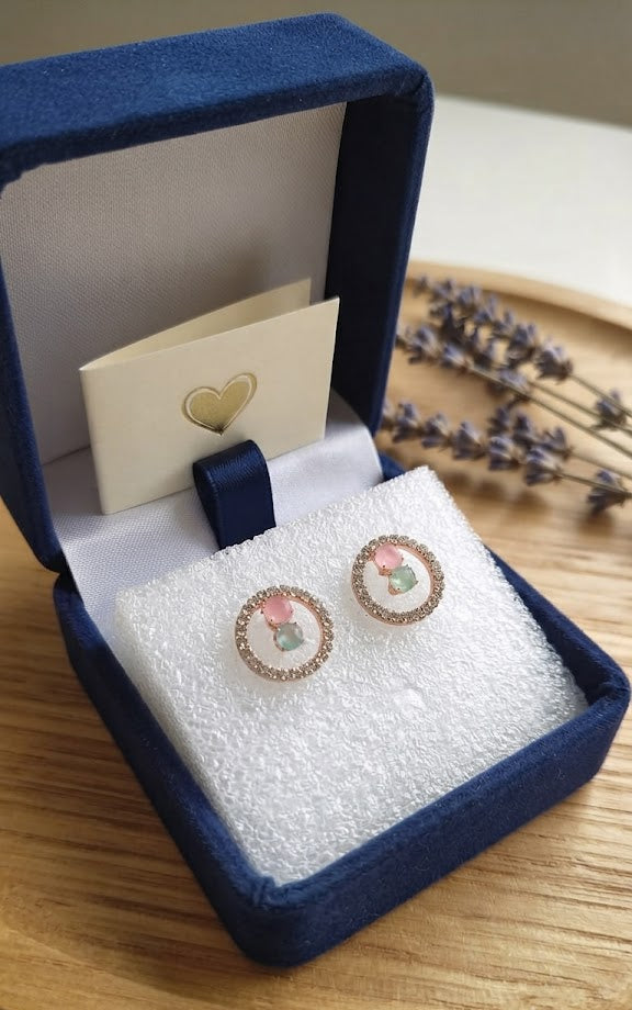 Rose gold pavé CZ open circle halo pink rose quartz and mint green aventurine stud earrings on dark black velvet with scattered loose CZ stones and rose gold beads – AureliaBlends dark editorial statement stud earrings