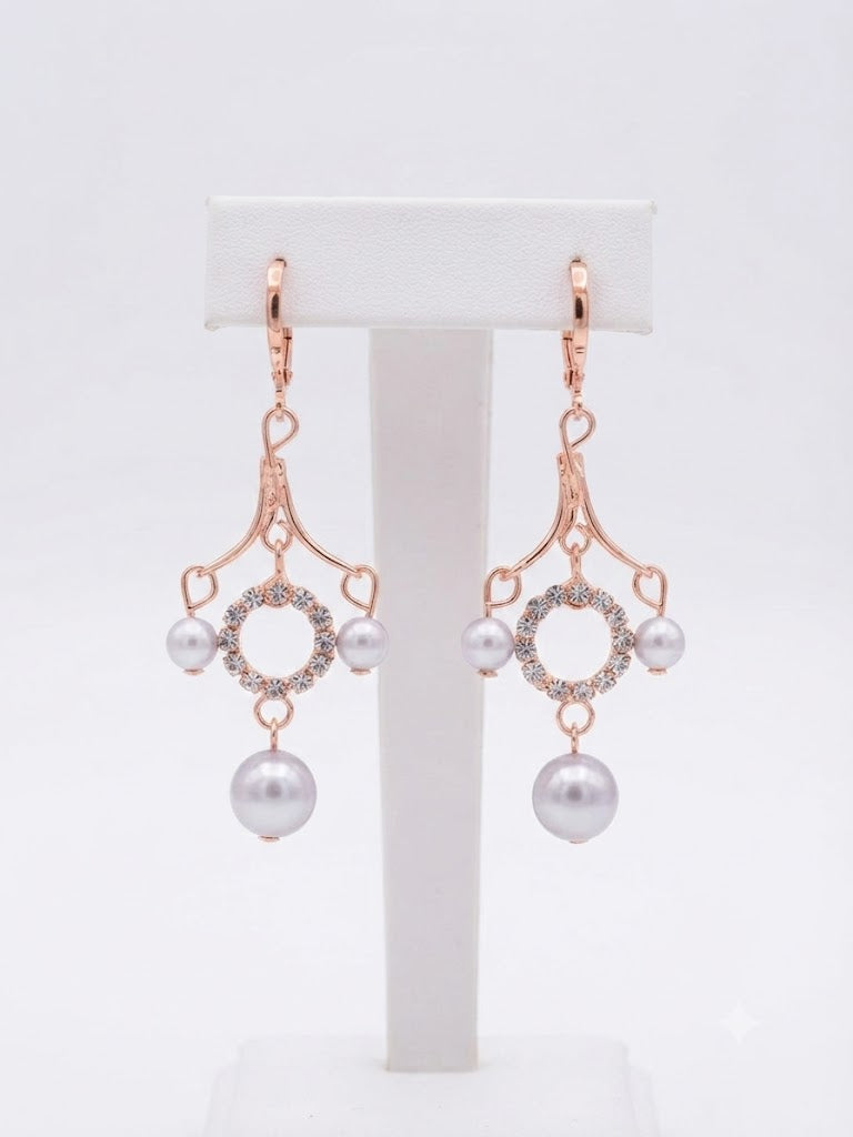 Rose gold CZ pavé circle pearl chandelier leverback drop earrings on a clear acrylic display stand against a soft grey satin background – AureliaBlends bridal dangle earrings hero product shot