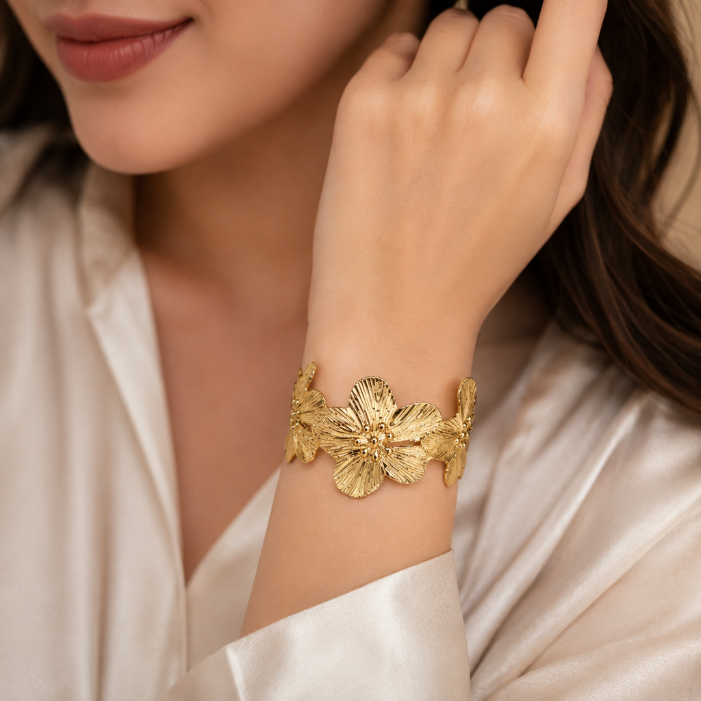 Gold hibiscus wide cuff bracelet on luxury jewelry display stand in fine jewellery boutique – AureliaBlends