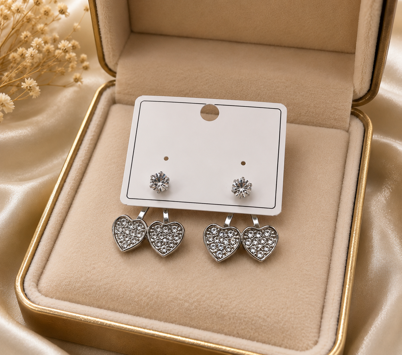 Silver CZ double heart ear jacket earrings flat lay on white marble with loose CZ stones, a cream leather jewellery case, gold pen and Diamond Heart Collection tag – AureliaBlends